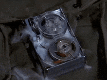 a close up of a tape recorder with smoke coming out of it on a table