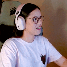 a woman wearing glasses and headphones with a corsair logo on the back of her chair