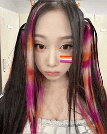 a woman with rainbow hair has a lesbian flag on her face