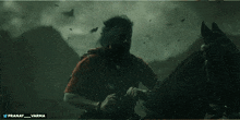 a man in a red shirt is riding a horse with the words pranay and varma below him