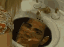 a man 's head is sticking out of a sink in a bathroom