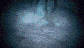 a person is walking through a dark room with a spotlight on the floor .