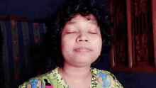 a woman with her eyes closed wearing a green shirt that says ' i love you '