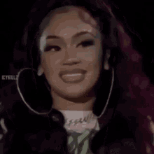 a close up of a woman wearing hoop earrings and smiling .