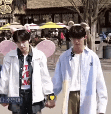 two young men are holding hands in front of a sign that says express .