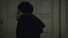 a man is standing in front of a door with a sign that says ' a ' on it