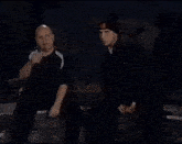 a man kisses another man on the cheek in a dark room