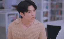 a blurry picture of a man sitting at a desk in front of a computer .