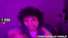 a man is smiling in front of a purple background with the number 1250