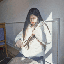 a woman with long hair is sitting at a table with a cell phone