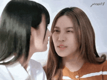 a couple of women are kissing each other on the cheek .