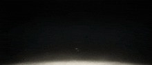 a robot is flying through the air with a light coming out of it 's mouth .