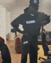 a man wearing a black hoodie that says welllad worker is standing in a room