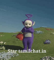 a purple teletubbies character is holding a red bag in a field