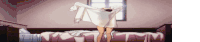 a person is standing on a bed holding a white shirt over their head .