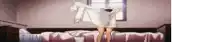 a person is standing on a bed holding a white shirt over their head .