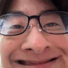 a close up of a person wearing glasses making a face .