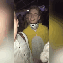 a young man in a yellow costume is smiling in a crowd .