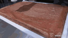 a large piece of chocolate cake is being made by animatica