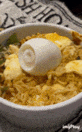 a bowl of noodles with an egg in it