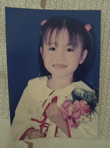 a picture of a little girl with a flower in her hair with the letter c on it