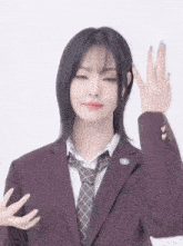 a girl wearing a purple suit and tie making a peace sign