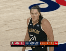 a washington basketball player stands on the court
