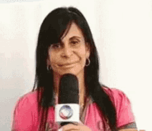 a woman is smiling while holding a microphone in her hand .