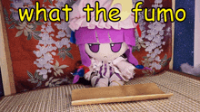 a stuffed doll with purple hair is sitting on a mat with the words what the fumo above her