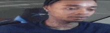 a man in a blue shirt is making a funny face while looking at the camera .