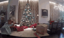 a christmas tree is surrounded by presents and a cardboard box that says ' i love you ' on it