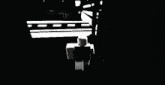 a black and white drawing of a person standing on a sidewalk in a dark room .
