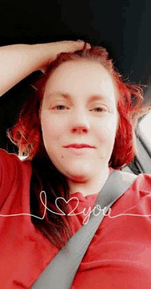 a woman with red hair is wearing a red shirt with the words i love you written on it