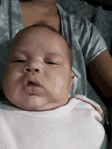 a baby is laying upside down on a person 's lap .