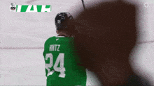 a hockey player in a green jersey with the number 24 on it
