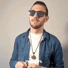a man wearing sunglasses and a denim shirt has the word mean on the bottom