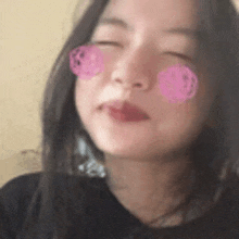 a close up of a woman 's face with a pink flower on her cheeks .