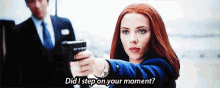 a woman is pointing a gun at a man in a suit and tie and says `` did i step on your moment ? ''