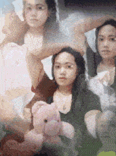 a woman holding a pink teddy bear in front of her face