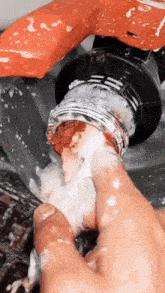 a close up of a person cleaning a faucet with their fingers .