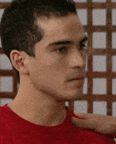 a close up of a man 's face with a red shirt on