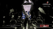 a woman is dancing in front of a sign that says watch all your shows on yodesi net