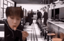 a young man is eating food with a fork in a restaurant .