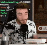 a man wearing headphones is sitting in front of a microphone with the words totally_notangel_trust on the screen