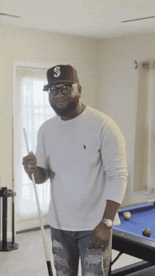 a man holding a pool cue with the letter s on it