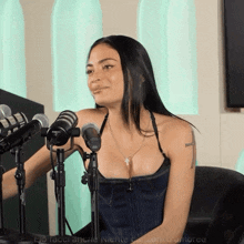 a woman sitting in front of a row of microphones with the word amoree on the bottom left