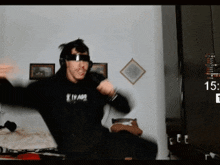 a man wearing headphones and a hoodie that says thrasher is dancing in a room