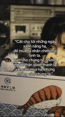 a cat laying on top of a box of sushi next to a woman ..