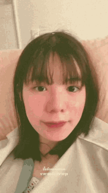 a woman laying on a bed with a foreign language written on the bottom right