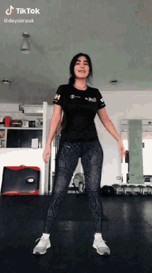 a woman is dancing in a gym with the hashtag tiktok at the top